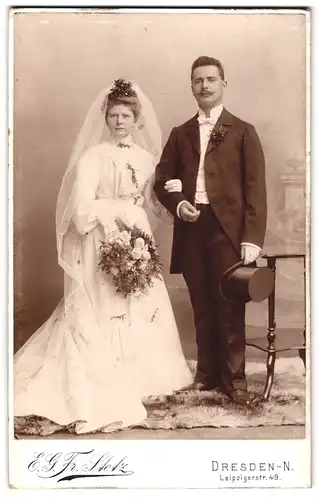 Fotografie E. G. Fr. Stotz, Dresden, Leipzigerstr. 49, junge Brautleute im Hochzeitskleid und Anzug mit Zylinder