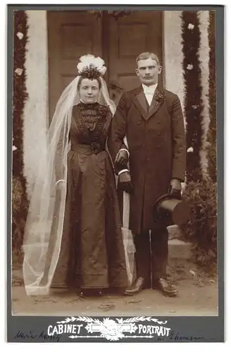 Fotografie unbekannter Fotograf und Ort, Portrait Anna und Gustav Ranig im schwarzen Hochzeitskleid und Anzug, Zylinder