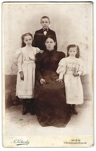 Fotografie N. Kotarsky, Wien, Matzleinsdorferstr. 49, Portrait jugne Mutter mit ihren drei Kindern im Atelier