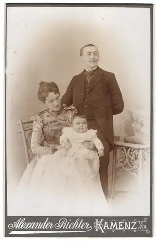 Fotografie Alexander Richter, Kamenz i. Sa., junge Mutter und Vater mit kleiner Tochter auf dem Schoss, Mutterglück