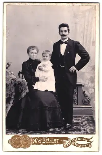 Fotografie Max Seifert, Freiberg i. S., Poststr. 11, junge Eltern mit ihrem Kind auf dem Schoss im Atelier, Mutterglück