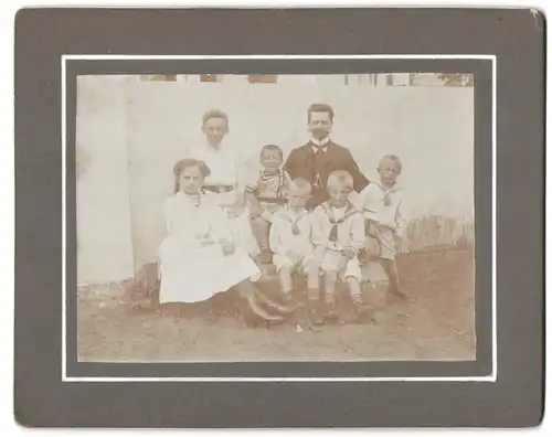 Fotografie unbekannter Fotograf und Ort, Mutter und Vater mit ihren fünf Kindern im Garten, Mutterglück