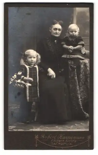 Fotografie Robert Hannemann, Satrup i. A., Grossmutter mit ihren beiden Enkelkindern im Atelier