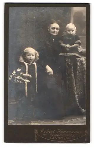 Fotografie Robert Hannemann, Satrup i. A., Portrait Grossmutter mit zwei süssen blonden Enklekindern im Atelier