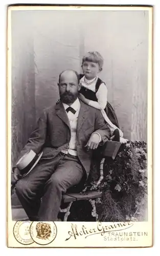 Fotografie Anton Grainer, Traunstein, Stadtplatz, Portrait Vater im Anzug mit Hut und seiner Tochter auf der Lehne