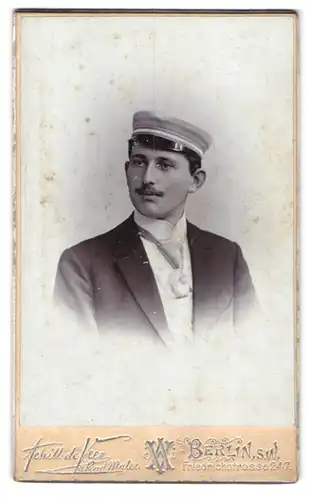 Fotografie Achill de Ver, Berlin, Friedrichstr. 247, Student im Anzug mit Schirmmütze und Moustache