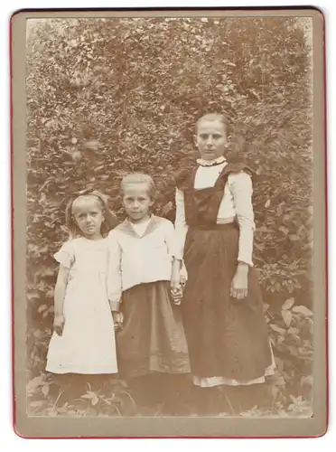 Fotografie unbekannter Fotograf und Ort, Kindermädchen mit Schürze und ihren beiden Zöglingen im Garten