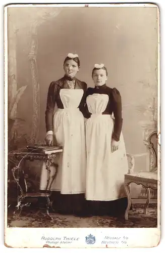 Fotografie Rudolph Thiele, Neusalz a. O., zwei junge polnische Dienstmädchen in Uniform posieren im Atelier