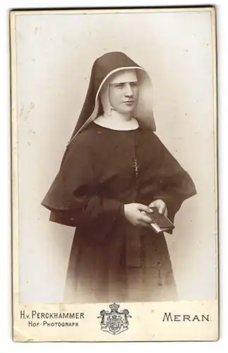 Fotografie H. v. Perckhammer, Meran, junge Nonne im Habit mit Bibel in der Hand