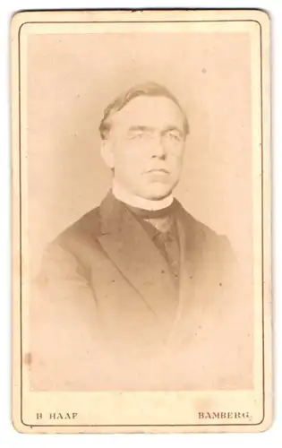 Fotografie B. Haap, Bamberg, Portrait Pastor im Anzug mit Collar