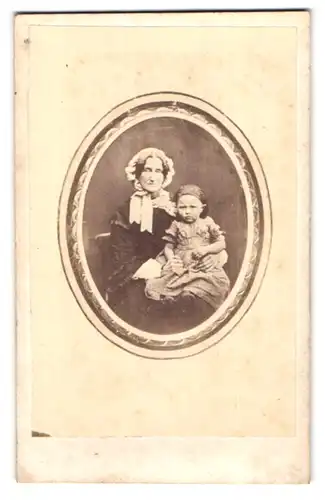 Fotografie unbekannter Fotograf und Ort, Portrait Grossmutter mit seiner Enkeltochter im Atelier, Mutterglück