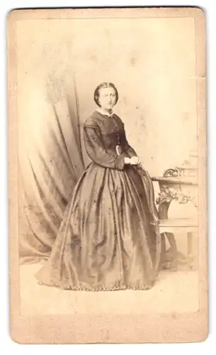 Fotografie Albert Schwendy, Berlin, Brüderstr. 2, junge Dame im seidenen Kleid stehend am Stuhl