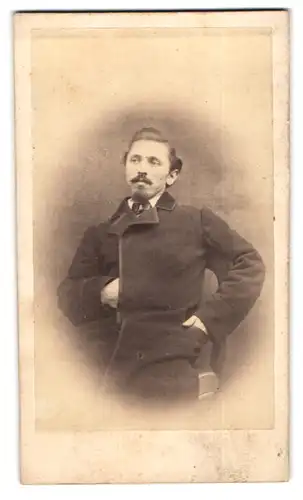 Fotografie unbekannter Fotograf und Ort, Portrait junger Mann im Mantel mit Moustache und Napoleon Geste
