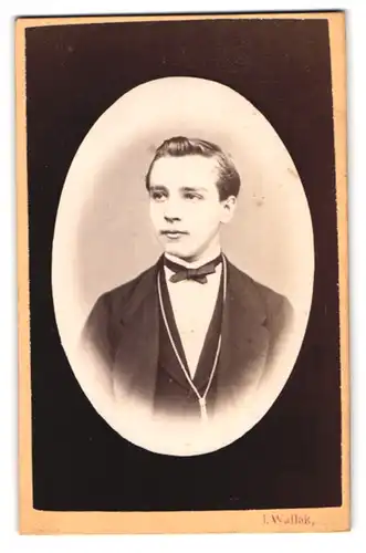 Fotografie L. Wallak, Wien, Schleifmühlgasse, junger Mann im feinen Anzug mit Halskette und Fliege