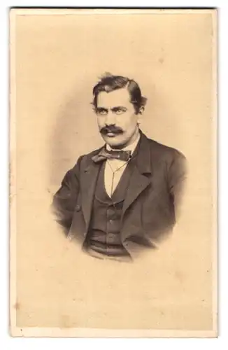 Fotografie Johann Kuhn, Mähr. Trübau, Portrait Herr im dunkeln Anzug mit Fliege und Moustache