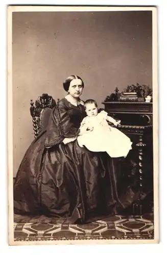 Fotografie W. Breuning, Hamburg, junge Mutter im seidenen Biedermeierkleid mit Kleinkind auf dem Schoss, Mutterglück