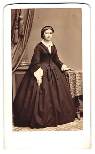 Fotografie Heinrich Bucker, Dresden, Pragerstr. 5, Dame im dunklen reifrock Kleid mit Brosche und Haarnetz