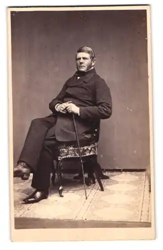 Fotografie J. Petersen, Odense, dänischer Herr im dunklen Anzug mit Flanierstock und Backenbart sitzt auf einem Stuhl