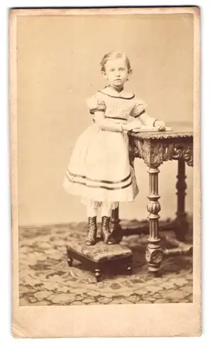 Fotografie August Stecher, Leipzig, Salomonstr. 4, niedliches kleines Mädchen im hellen Kleid steht auf einem Tritt 1870