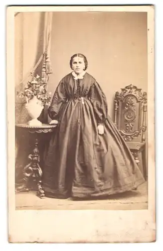 Fotografie Otto Wigand, Zeitz, Portrait Dame im Biedermeierkleid stehend am Tisch