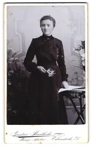 Fotografie Gustav Bartholi, Eibenstock, Junge Frau im dunklen Gewand mit Maiglöckchen