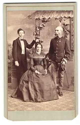 Fotografie Leopold Wittmann, Wien, Lange Gasse 60, Mutter und Vater Lampe in Uniform mit ihrem Sohn im Atelier
