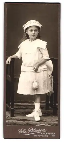 Fotografie Chr. Petersen, Sonderburg, Brandtsweg, Portrait kleines Mädchen im weissen Kleid mit Säckchen und Hut