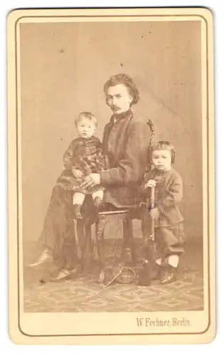 Fotografie W. Fechner, Berlin, Krausen-Str. 21, Vater im Anzug posiert mit seinen zwei Kindern im Atelier