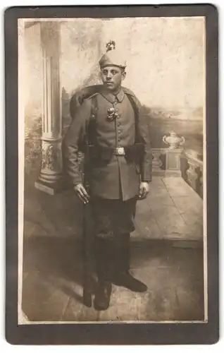 Fotografie unbekannter Fotograf und Ort, junger Uffz. in Feldgrau Uniform mit Ausmarschgepäck, Picklehaube Tarnbezug