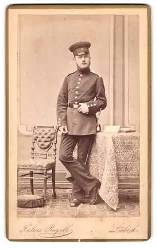 Fotografie Julisu Rogall, Lübeck, Breitestr. 788, junger Soldat in Uniform mit Bajonett im Atelier