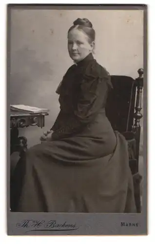 Fotografie Th. H. Backens, Marne, Dame mit Dutt im eleganten Kleid