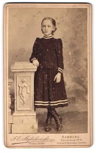 Fotografie I. E. Stybalkowski, Hamburg, Steinstrasse 61, Mädchen in dunklem Kleid und Stiefeln