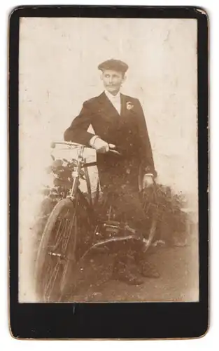 Fotografie unbekannter Fotograf und Ort, junger Mann im Anzug lehnt an seinem Fahrrad