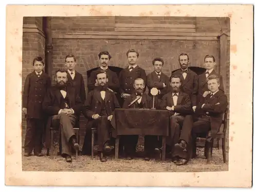 Fotografie unbekannter Fotograf und Ort, Wissenschaftler mit Aparatur auf dem Tisch beim Gruppenfoto
