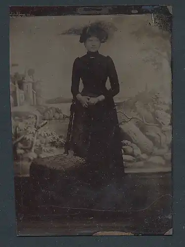 Fotografie Ferrotypie junge Frau im schwarzen Kleid vor einer Studiokulisse