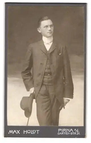 Fotografie Max Holdt, Pirna a. E., Gartenstr. 31, Portrait stattlicher junger Mann mit Flanierstock und Hut im Anzug