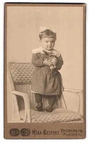 Fotografie Max Seifert, Freiberg i. S., Poststr. 11, Portrait süsses kleines Mädchen hält einen Ball in den Händen