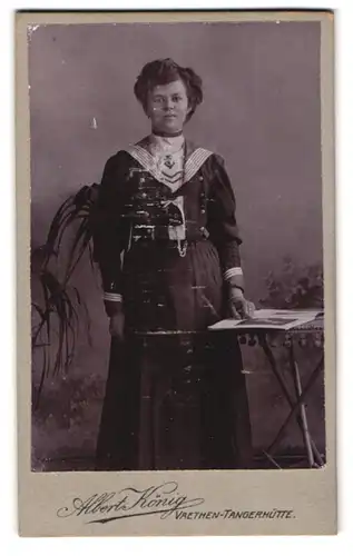 Fotografie Albert König, Vaethen-Tangerhütte, Portrait charmantes Fräulein im Matrosenkleid am Tisch stehend