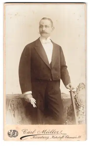 Fotografie Carl Müller, Hamburg, Hoheluft-Chaussée 35, Portrait stattlicher junger Mann mit Schnurrbart am Stuhl stehend
