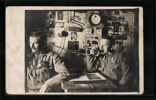 Foto-AK Zwei österreichische Soldaten in Uniform am Telefon mit Ansichtskarten an der Wand, Ansichtskartengeschichte