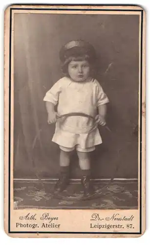Fotografie Arth. Beyer, Dresden, Leipzigerstr. 87, Kleines Kind mit Mütze hält Reifen