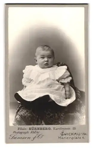 Fotografie Samson & Co., Zwickau i. Sa., Marienplatz, Portrait niedliches blondes Baby im weissen Rüschenkleidchen