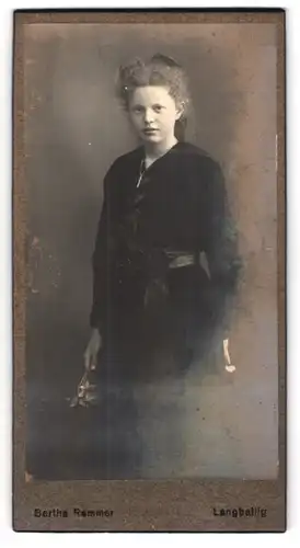 Fotografie Bertha Remmer, Langballig, Portrait bildschönes Mädchen mit Haarschleife und Blume in der Hand