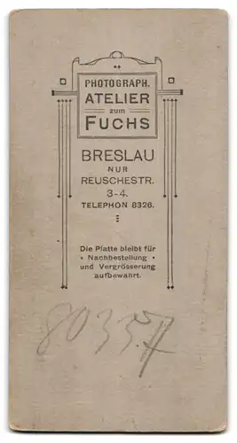 Fotografie Atelier Fuchs, Breslau, Reuschestr. 3-4, Portrait Bube elegant im Anzug am Stuhl stehend