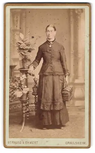 Fotografie Strauss & Ehmert, Crailsheim, Bahnhofstr., Portrait einer elegant gekleideten Frau mit Tasche in der Hand