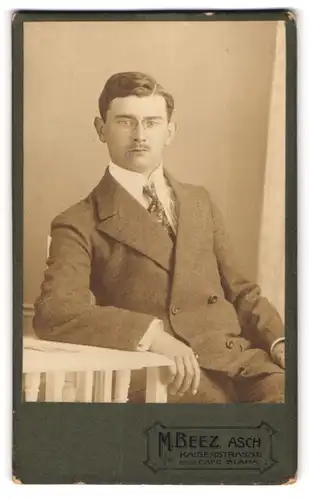 Fotografie M. Beez, Asch, Kaiserstr., Junger Herr im Anzug mit Zwicker