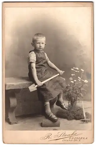 Fotografie R. Stanke, Dresden, Uhland-Str. 6, Portrait junger Knabe als Gärtner mit Spaten und Harke