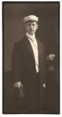 Fotografie Atelier Clauss, München, Portrait junger Student im Anzug mit Schirmmütze udn Couleur