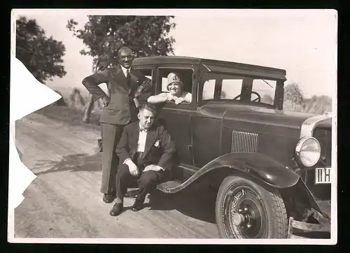 Fotografie Auto, Bursche im Anzug auf PKW - Trittbrett sitzend