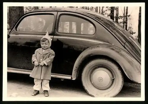 Fotografie Auto VW Käfer Ovali, Kind mit Zipfelmütze neben Volkswagen PKW